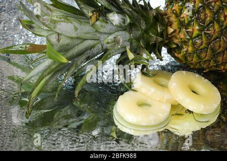 Big fresh pineapple close up on a water drops with small pineapple slices. Water splash . multivitamin cocktail. Pineapple juice. Healthy lifestyle. Stock Photo