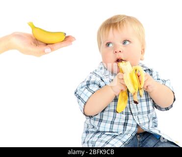 Feeding baby boy with banana isolated on white Stock Photo