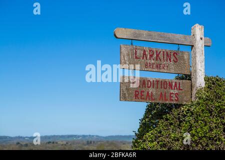 Old wooden hand painted sign hanging at Larkins Brewery award winning brewery and hop farm in Chiddingstone, Kent, UK Stock Photo