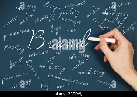 Female hand writing branding concept on blackboard with chalk, close-up Stock Photo