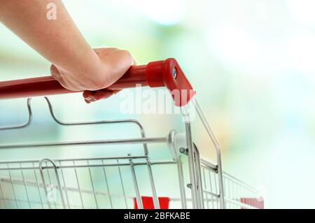 Young woman with shopping cart in store Stock Photo