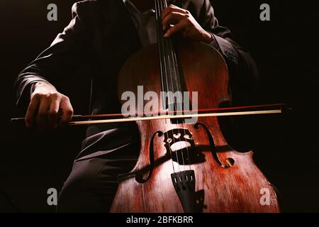 Man playing on cello on dark background Stock Photo