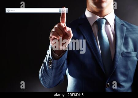 Searching system - businessman pressing search button Stock Photo