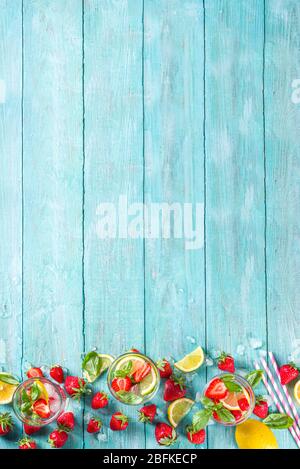 Strawberries and basil lemonade. Summer cold iced cocktail recipe, with fresh strawberry, lemon and basil leaves, wooden background copy space Stock Photo
