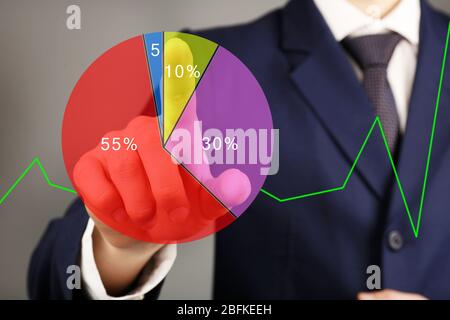 Businessman with financial graphic coming from hand Stock Photo