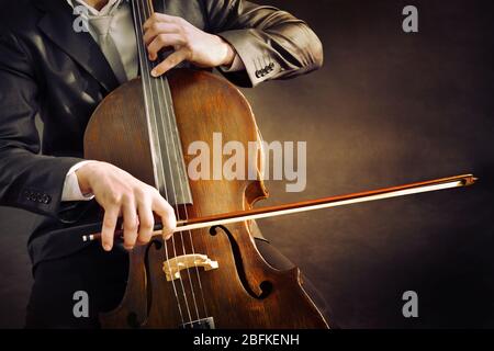 Man playing on cello on dark background Stock Photo