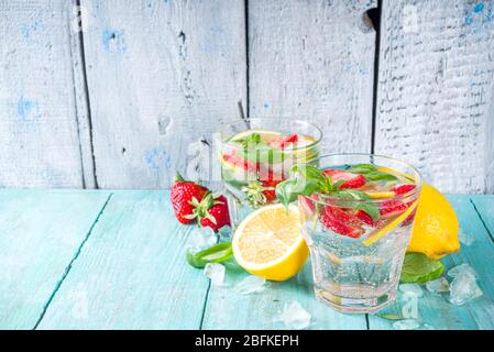Strawberries and basil lemonade. Summer cold iced cocktail recipe, with fresh strawberry, lemon and basil leaves, wooden background copy space Stock Photo