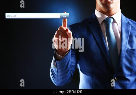 Searching system - businessman pressing search button Stock Photo