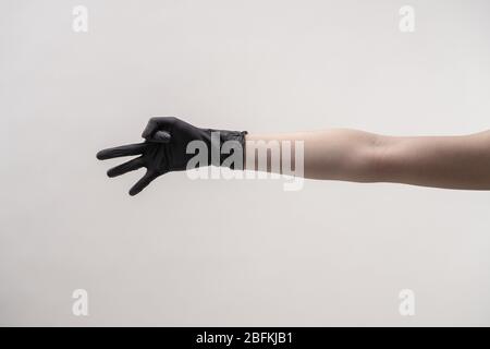 Hands in black silicone gloves on a light background. Stock Photo