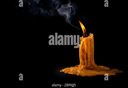 light flame candle burning brightly with smoke on black background Stock Photo