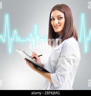 Young beautiful doctor with clipboard and cardiogram Stock Photo