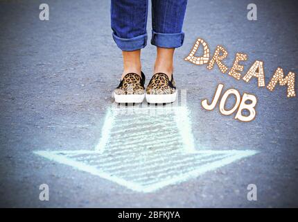 Dream job concept. Female feet and drawing arrows on pavement background Stock Photo