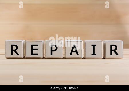 Word Repair made with cubes on wooden background Stock Photo