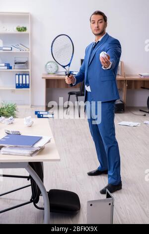 Young employee playing tennis in the office Stock Photo