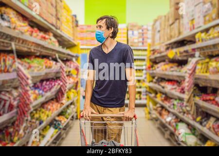 Alarmed man wears medical mask against coronavirus while grocery shopping in supermarket or store- health, safety and pandemic concept - young woman Stock Photo