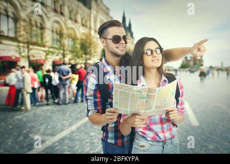 Happy tourists with map on street in city Stock Photo
