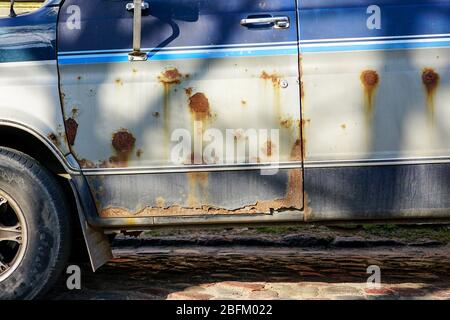 a fragment of a rusty car body on a city street Stock Photo