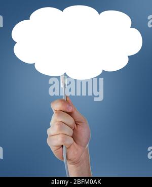 Internet cable in hand on blue sky background with cloud Stock Photo