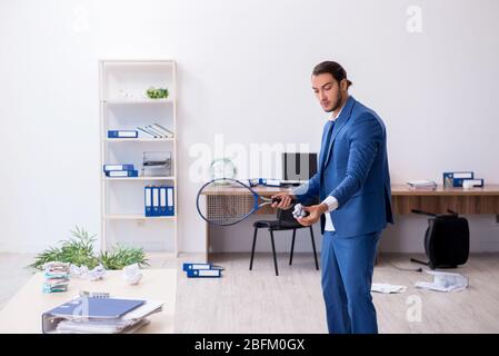 Young employee playing tennis in the office Stock Photo