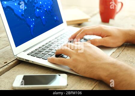 Human working with laptop, with world map and network on screen Stock Photo