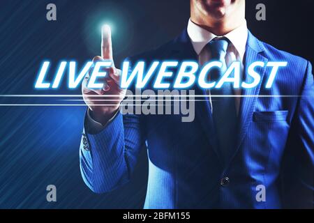 Businessman pressing live webcast button on virtual screen. Internet and networking concept. Stock Photo