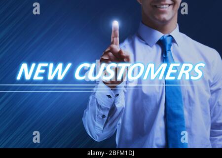 Businessman pressing new customers button on virtual screen. Internet and networking concept. Stock Photo