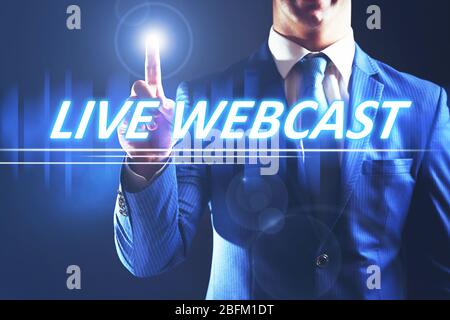 Businessman pressing live webcast button on virtual screen. Internet and networking concept. Stock Photo