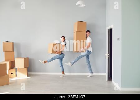 Funny middle-aged couple with cardboard boxes smiling in a new apartment. Stock Photo