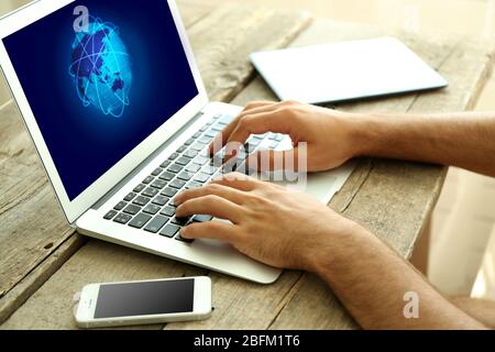 Human working with laptop, with world map and network on screen Stock Photo