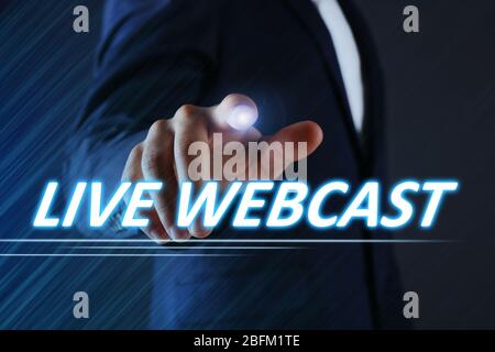 Businessman pressing live webcast button on virtual screen. Internet and networking concept. Stock Photo