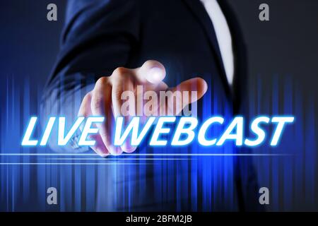 Businessman pressing live webcast button on virtual screen. Internet and networking concept. Stock Photo