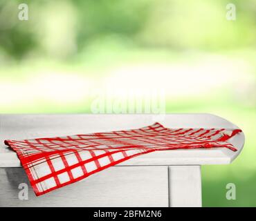 Wooden table with napkin on green blurred background Stock Photo