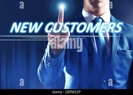 Businessman pressing new customers button on virtual screen. Internet and networking concept. Stock Photo
