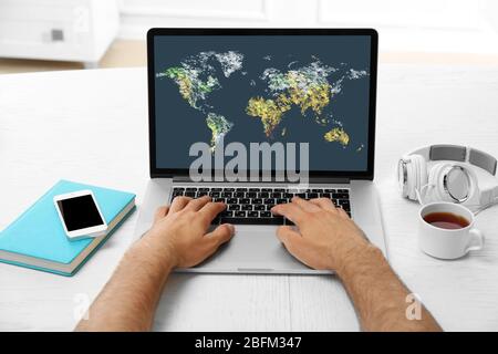 Human working with laptop, with world map and network on screen Stock Photo