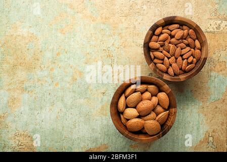 Fresh raw Almonds fruit in shell and shelled in wooden bowl. Almond concept with copyspace Stock Photo