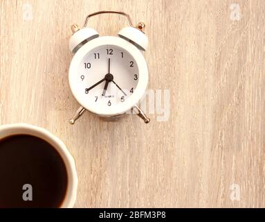 close up view of coffee maker, alarm clock and cup of coffee isolated on  red Stock Photo by LightFieldStudios