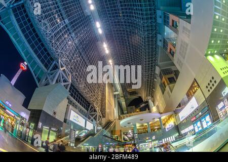 Kyoto, Japan - April 27, 2017: Kyoto Tower with Observation Deck view from inside of Kyoto Station central hall illuminated by night.Kyoto Station is Stock Photo