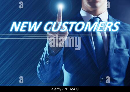 Businessman pressing new customers button on virtual screen. Internet and networking concept. Stock Photo