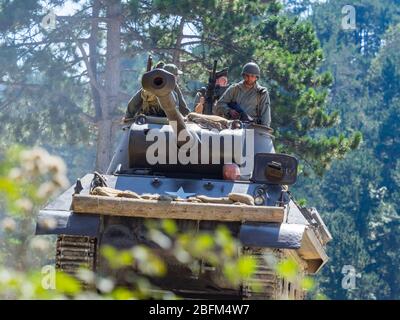 Reviving history of Slovenia Pivka museum of military history representing WW2 USA American army soldiers riding atop while driving tank Stock Photo