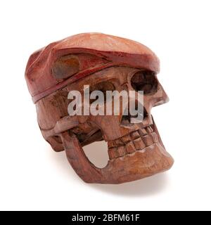 Sculpture of a wooden skull isolated in front of a white background Stock Photo