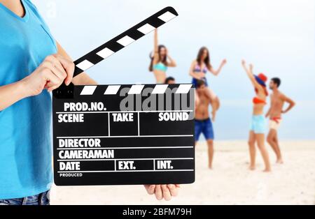Operator holding clapperboard during the production of film outdoor Stock Photo