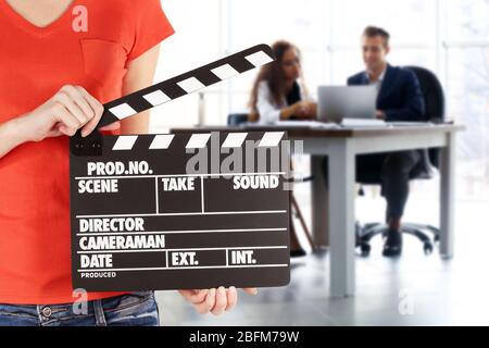 Operator holding clapperboard during the production of the film indoors Stock Photo