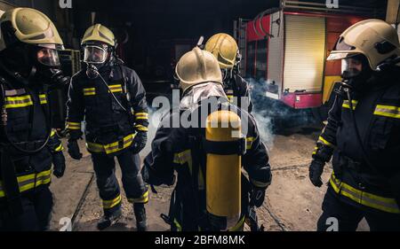 Group of firefighters in the fire department checking their gas mask equipment Stock Photo