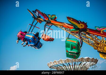 Vibrant seats of a roundabout swing ride at the local theme park Stock Photo