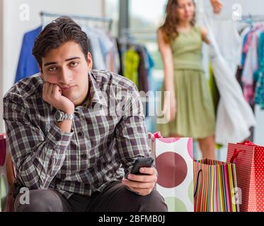 The man fed up with wife shopping in shop Stock Photo