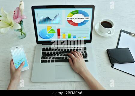 Woman working with modern laptop, with scheme on screen Stock Photo