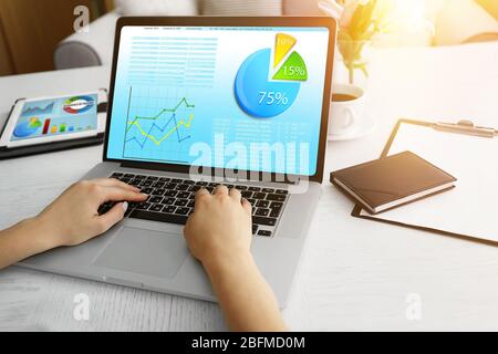 Woman working with modern laptop, with scheme on screen Stock Photo