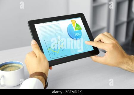 Businessman holding tablet-pc with scheme on screen Stock Photo