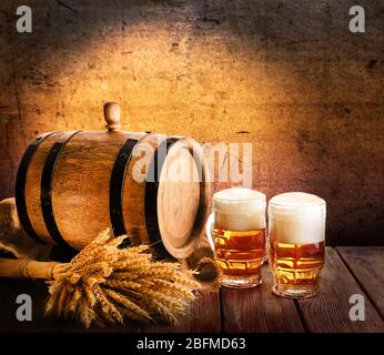 Beer barrel with beer glasses on table on brown background Stock Photo