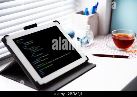 Programming code on tablet computer monitor Stock Photo